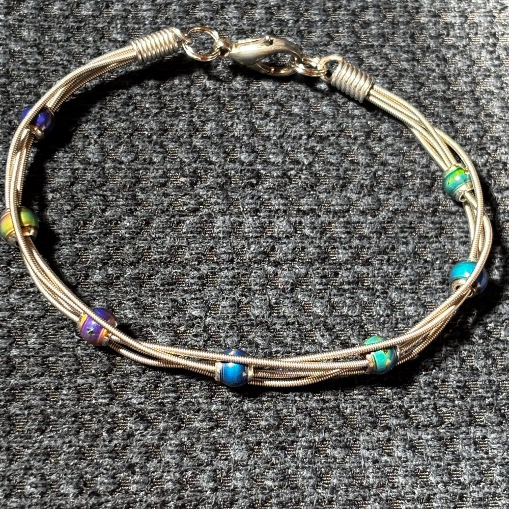 Clever bracelet made from real guitar strings. Bracelet is 7 inches long.